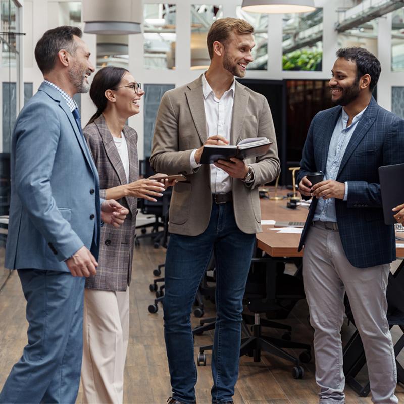 Businesspeople talking while standing in office during break. Teamwork concept. High quality photo