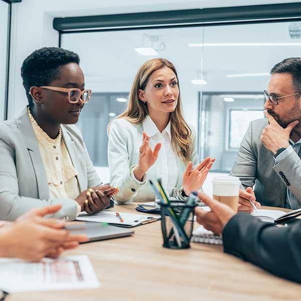 Women leaders sitting at desk with male leadership colleagues