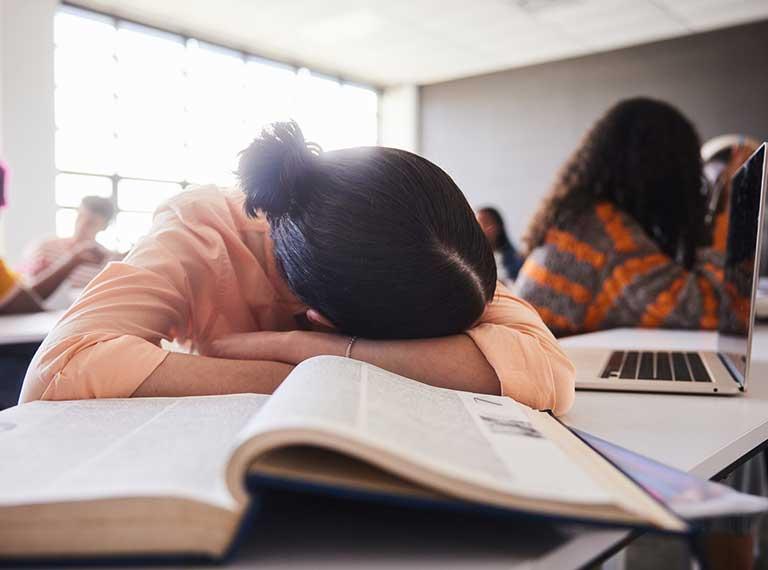Child crossing arms on table in frustration with ADHD